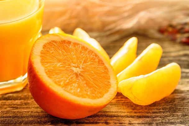 arance e succo d'arancia su fondo di legno - Foto, immagini