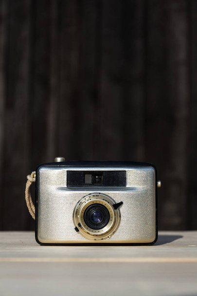 Old vintage golden Penti I camera from East German camera maker Welta on wooden background - Photo, Image