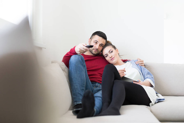 Young couple on the sofa watching television - Photo, Image