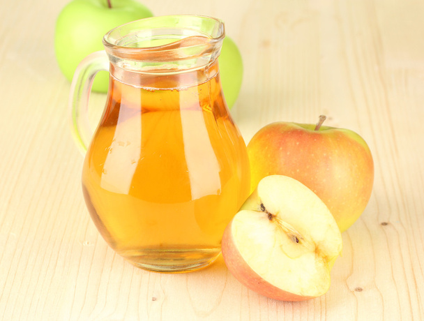 Full jug of apple juice and apple on wooden background - Foto, immagini