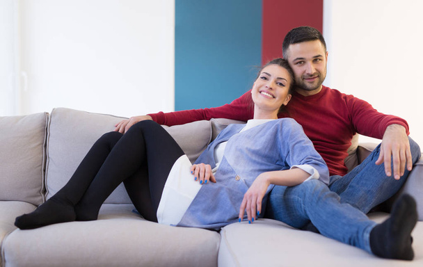 couple hugging and relaxing on sofa - Foto, afbeelding