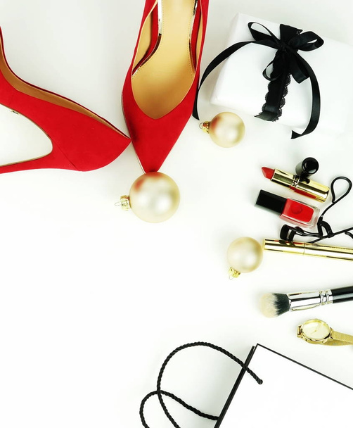 Fashion female accessories: red high-heeled shoes, gift, cosmetics, package, accessories and Christmas balls on a white background. Copy space - Valokuva, kuva