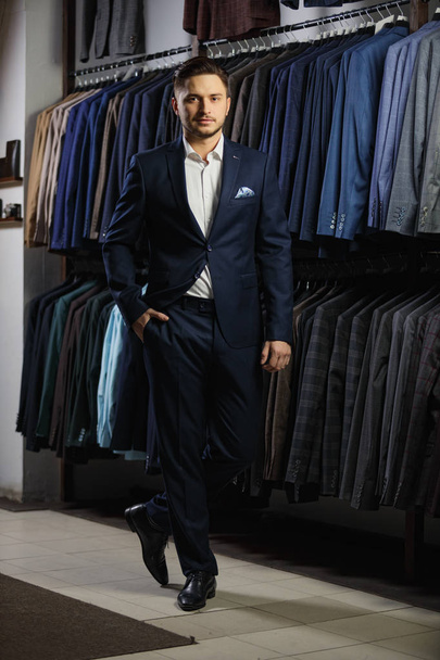 Handsome caucasian businessman dressed in the suit in suit shop - Photo, Image