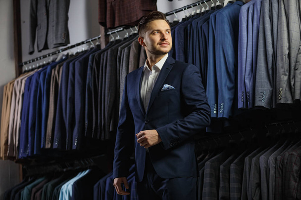 Handsome caucasian businessman dressed in the suit in suit shop - Фото, зображення