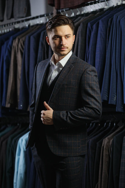 Handsome businessman in classic suit. A young stylish man in a jacket. It is in the showroom, trying on clothes, posing. Advertising photo - Zdjęcie, obraz