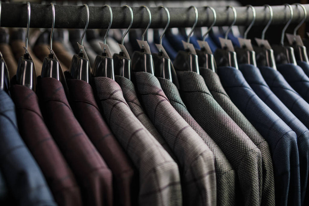 Row of men suit jackets on hangers - Фото, изображение