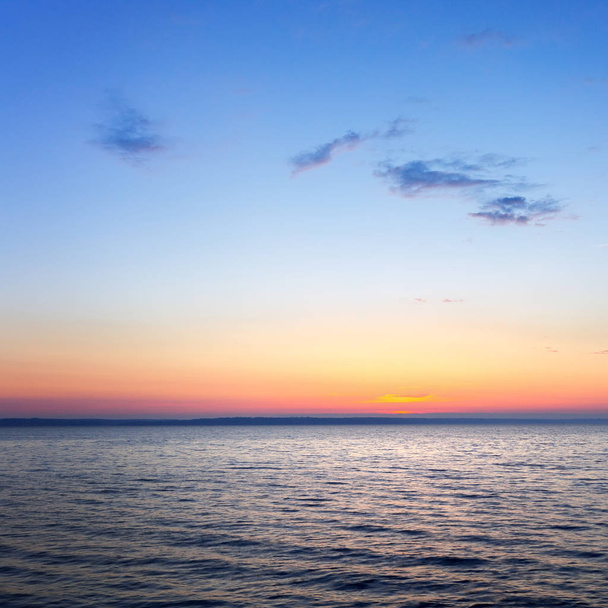 the dawn of a clear sky, calm water  - Фото, зображення
