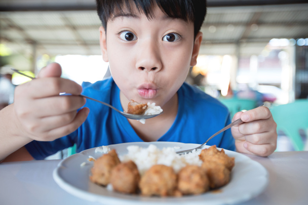 Asiatique mignon garçon manger petit déjeuner et regarder caméra avec sourire visage
  - Photo, image