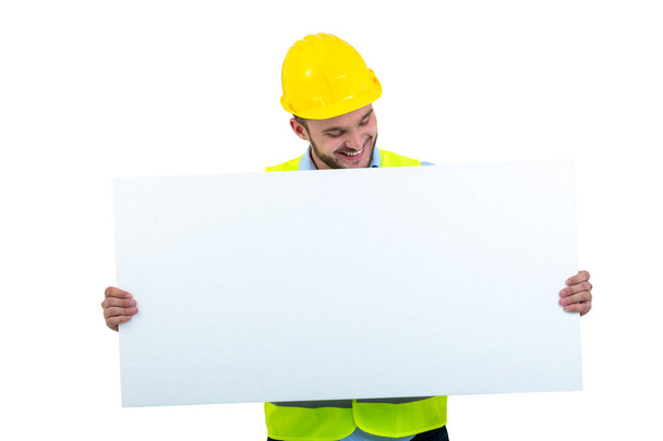 Happy male engineer holding an advertisement blank banner. Isolated on white background - 写真・画像