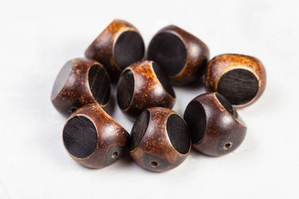 коричневые бусины, вырезанные из натурального рога на сером
 - Фото, изображение