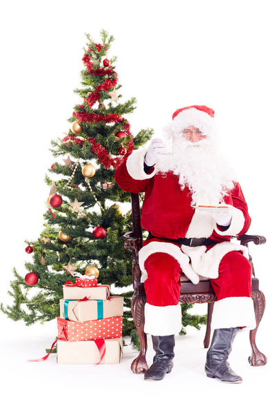 Santa near Christmas tree - Фото, изображение