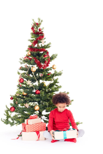 Mixed race boy near Christmas tree - Zdjęcie, obraz