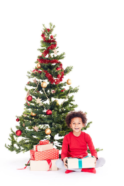 Mixed race boy near Christmas tree - Fotografie, Obrázek