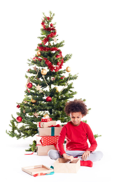 Boy unpacking Christmas gifts - Foto, immagini
