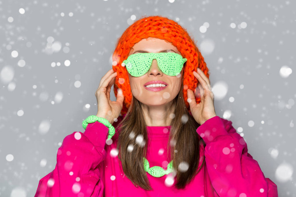 Unusual winter woman wearing bright outfit with falling snow - Photo, Image