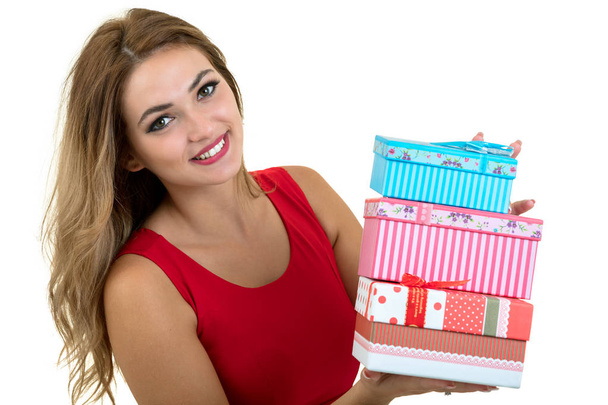 Portrait of a smiling pretty girl holding stack of gift boxes isolated over white background - Foto, afbeelding