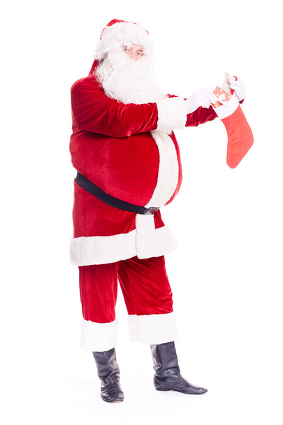 Weihnachtsmann versteckt Geschenk in Strumpf - Foto, Bild