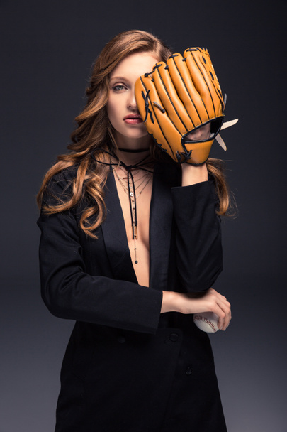 sexy woman covering eye with baseball mitt isolated on gray - Photo, Image