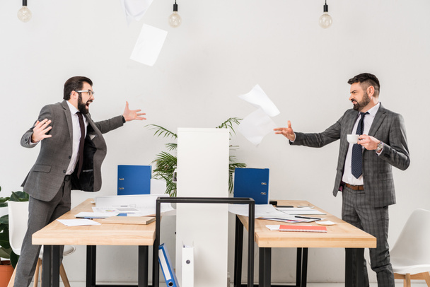 businessmen quarreling in office and throwing documents - Фото, изображение