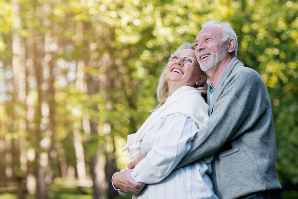 Happy senior couple hugging   outdoors in nature - Фото, зображення