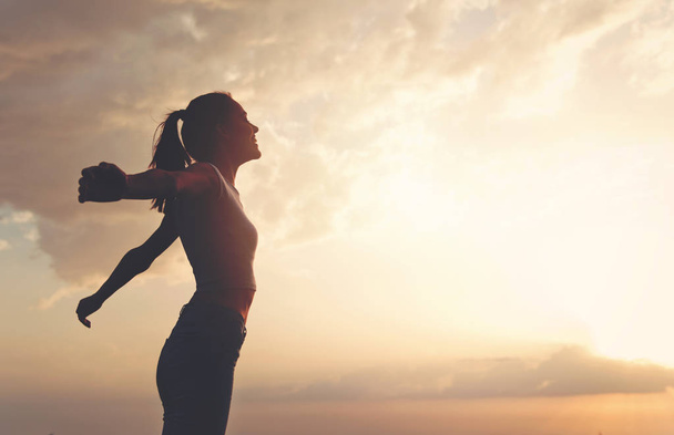 Молода жінка насолоджується на відкритому повітрі, фон неба
 - Фото, зображення