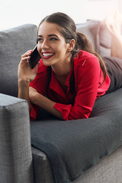 Beautiful young businesswoman using a cellphone on a sofa - Fotó, kép