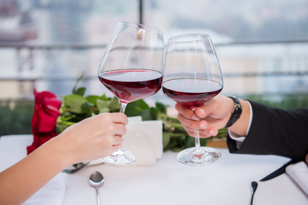 Schnappschuss von Paar, das beim Feiern des Valentinstages im Restaurant mit Rotweingläsern klingelt - Foto, Bild
