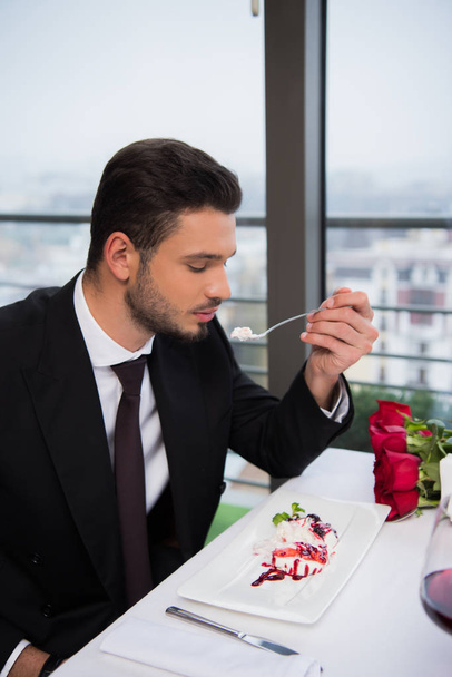 вид збоку чоловіка, який їсть десерт в ресторані
 - Фото, зображення
