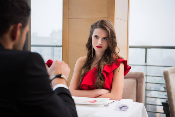 vista parcial de la mujer mirando novio con regalo en el restaurante el día de San Valentín
 - Foto, Imagen