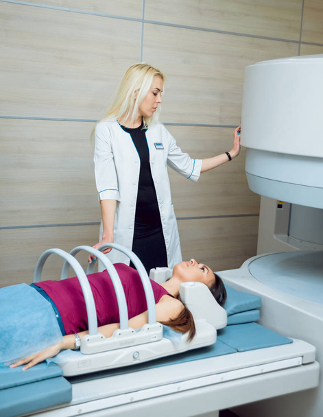 Femmina medico caucasico e femele paziente medio orientale in camera MRI in ospedale
. - Foto, immagini