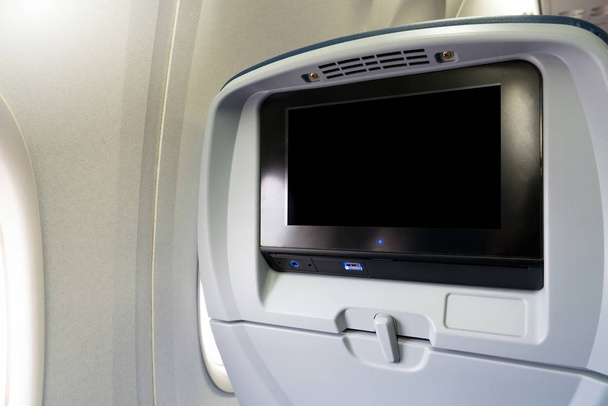 Крупный план ЖК-монитора экрана заднего сиденья на плоскости технологии для развлечений. Самолетные сиденья с монитором для развлечения пассажиров на борту
. - Фото, изображение