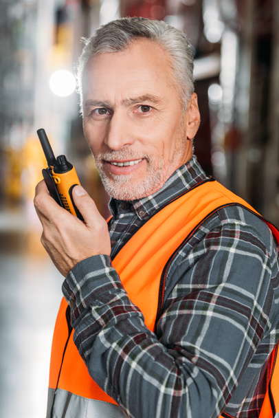 trabajador senior usando walkie talkie en el almacenamiento
 - Foto, Imagen