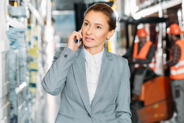 businesswoman talking on smartphone in shipping stock - Photo, Image
