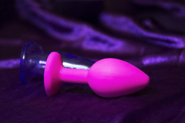 Silicone dildo Sex toy and a pink rose on a dark background. - Foto, afbeelding
