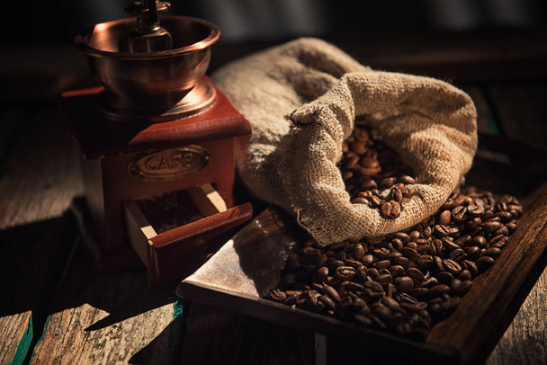 Coffee mill on dark rustic background. Wood table - Fotoğraf, Görsel