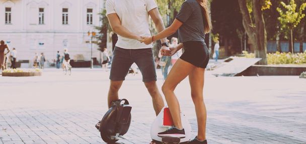 Young caucasian couple riding segways across city - Foto, afbeelding