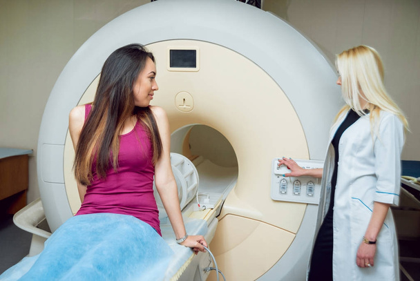 Femmina medico caucasico e femele paziente medio orientale in camera MRI in ospedale
. - Foto, immagini