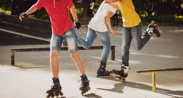 Young rollers practicing tricks in skatepark - Fotoğraf, Görsel