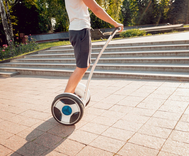 Young caucasian man riding on segway in city park - Foto, Imagen