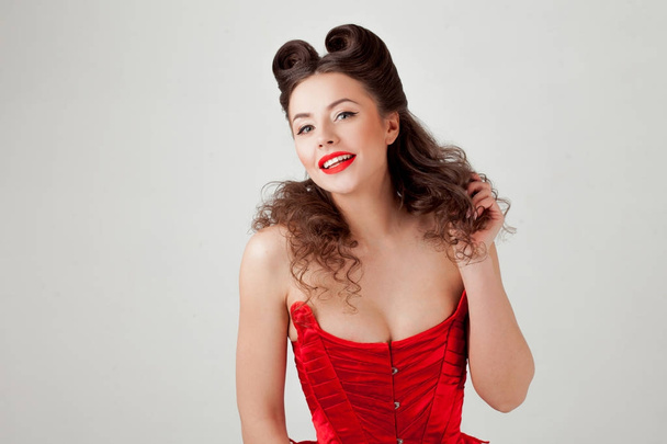 Charming lady in red corset, pin-up hairstyle - Foto, Imagem