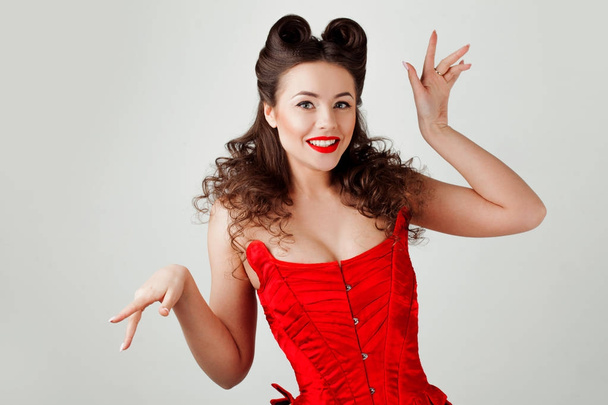 Charming lady in red corset, pin-up hairstyle - Фото, изображение
