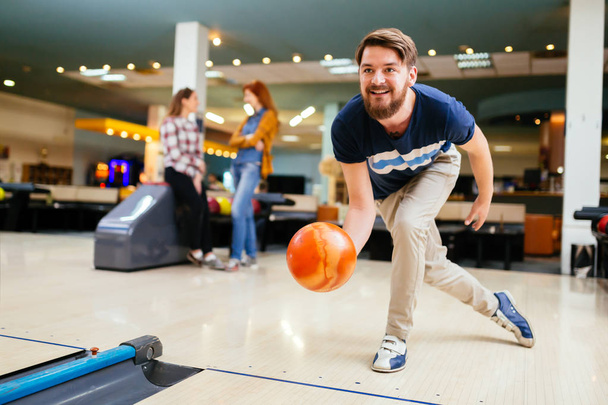 Handsome man throwing bowling ball - Photo, image