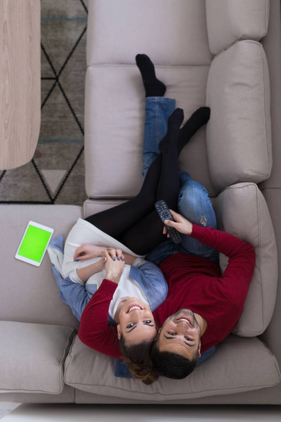 Young couple on the sofa watching television top view - Foto, Bild