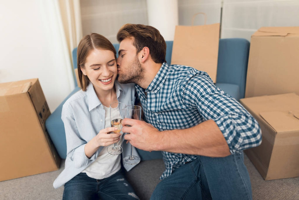 Young couple celebrating with champagne moving to new apartment. Moving newlyweds to new housing. - 写真・画像