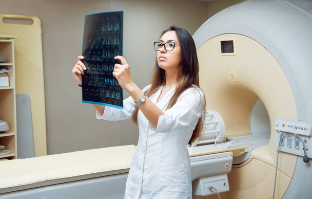 Young female middle eastern doctor looking at MRI picture. Medical equipment.  - Fotoğraf, Görsel
