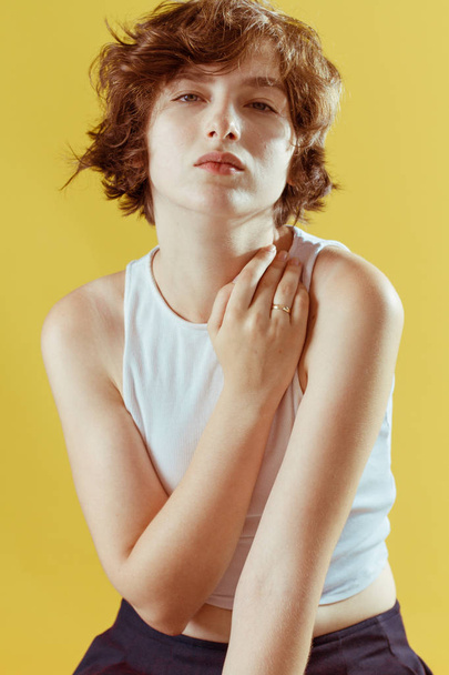 Beautiful and emotional girl on a yellow background without make-up and with natural skin - Fotografie, Obrázek