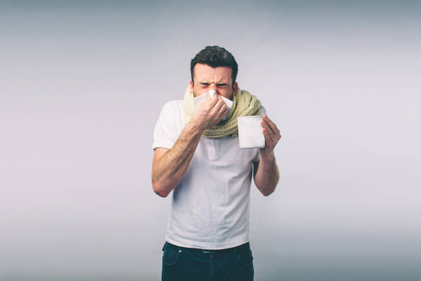 Atelierbild eines jungen Mannes mit Taschentuch. Kranker Mann isoliert hat laufende Nase. Mann macht Heilmittel gegen Erkältung: Nerd trägt Brille - Foto, Bild