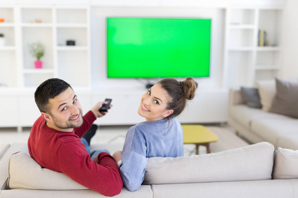 Young couple on the sofa watching television - Valokuva, kuva