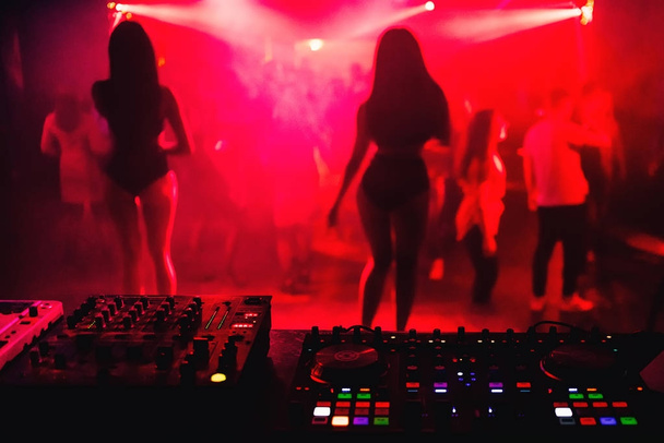 equipo de música mezclador de DJ en el club nocturno con siluetas borrosas
 - Foto, Imagen