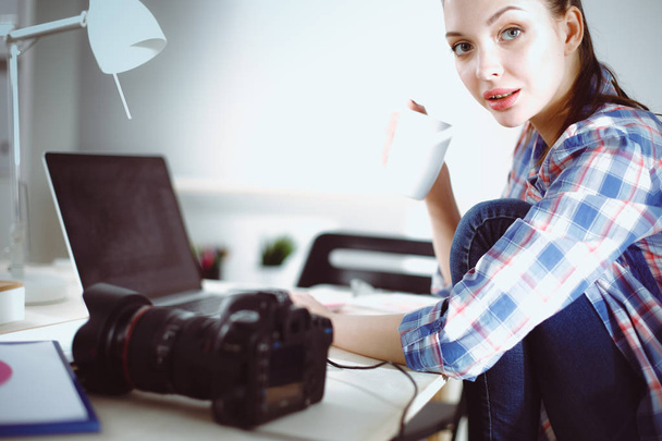 Female photographer sitting on the desk with laptop . Female photographer - Foto, Imagem